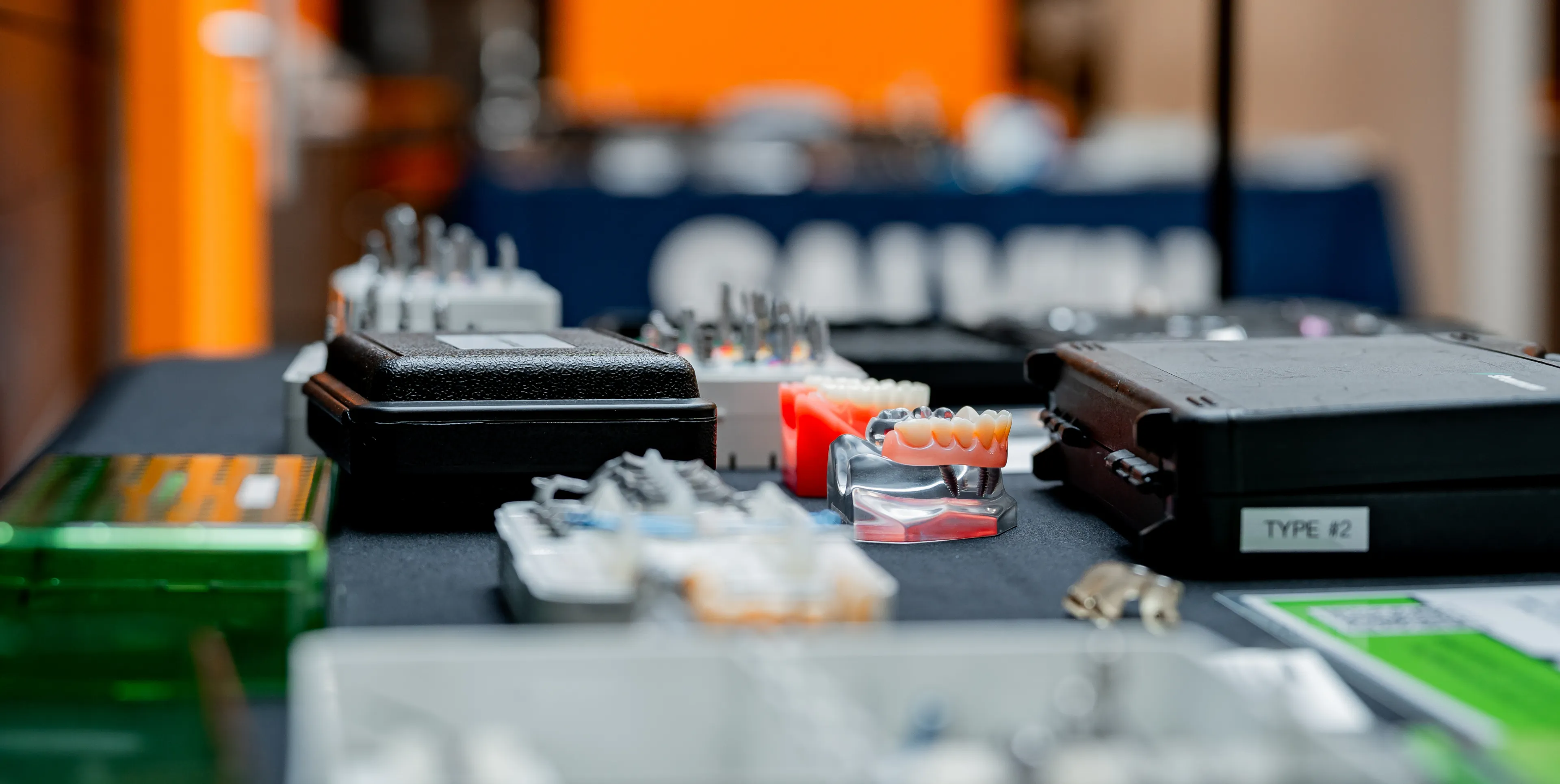 Dental tools and equipment are neatly arranged on a black table.