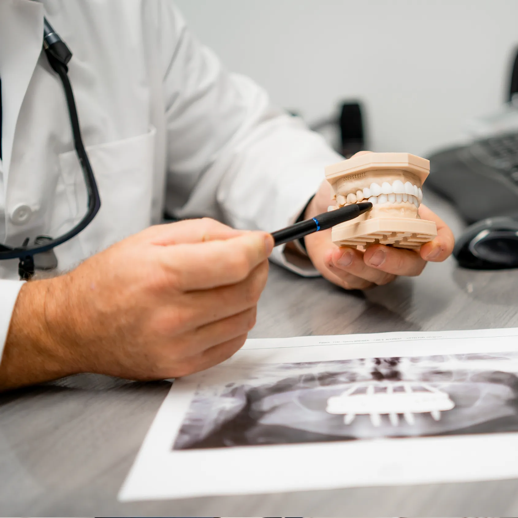 Close up of a dentist explaining procedure with a denture