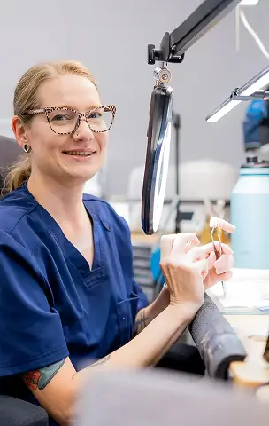 Technician holding a denture