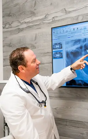 Dentist reviewing an X-ray on a screen