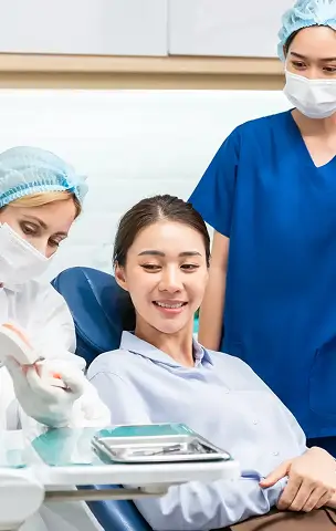 Dentist showing a model of teeth to a patient